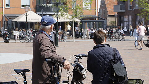 Echtpaar kijkt met fiets in de hand naar terrassen