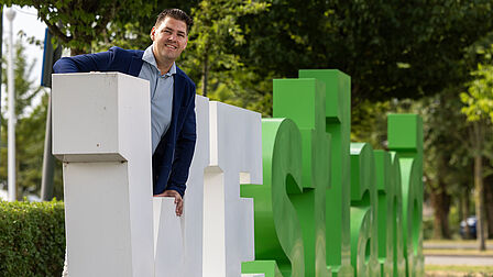 Dave van Koppen Westlandletters Op de foto staat een man voor een aantal witte en groene letters met 'Westland' erop
