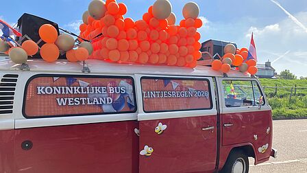 foto van busje tijdens lintjesregen