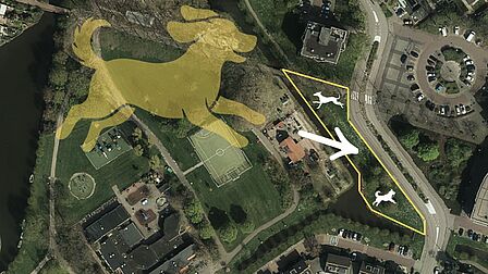 Het mogelijke hondenlosloopgebied in het Dreespark in Naaldwijk Op de afbeelding zie je met gele lijnen een gebied gekaderd staan waarin twee witte fictieve honden in zijn gezet. Verder wijst een witte pijl van een gele grote hond naar het gebied met gele lijnen.