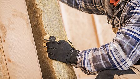 Een man is hier een muur aan het isoleren